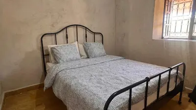 a bed with a metal frame in a bedroom at Escapade famille - vue panoramique et piscine privée in Aït Ghemat