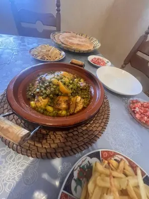 a table with a plate of food and french fries at Escapade famille - vue panoramique et piscine privée in Aït Ghemat