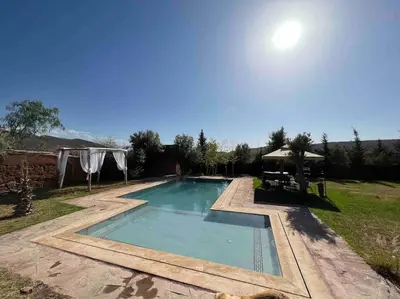 a swimming pool in a yard with a gazebo at Escapade famille - vue panoramique et piscine privée in Aït Ghemat