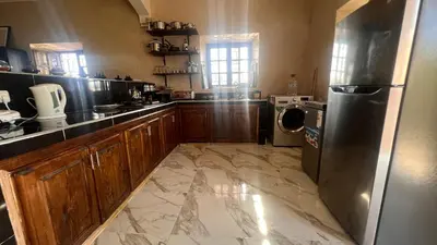 a kitchen with a refrigerator and a washer and dryer at Escapade famille - vue panoramique et piscine privée in Aït Ghemat