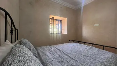 a bedroom with a bed and a window at Escapade famille - vue panoramique et piscine privée in Aït Ghemat