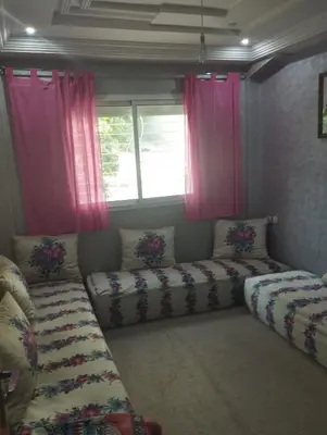 a living room with two couches and pink curtains at Appartement à louer à imouzzar kander in Imouzzer Kandar