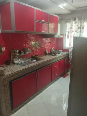 a kitchen with red cabinets and a red wall at Appartement à louer à imouzzar kander in Imouzzer Kandar