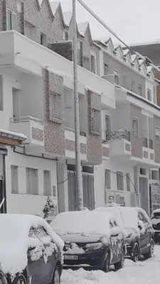 two cars covered in snow in front of a building at Appartement à louer à imouzzar kander in Imouzzer Kandar