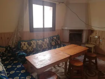 a living room with a couch and a wooden table at Gite Oukaimeden in Oukkainrdem