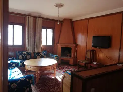 a living room with a table and a tv at Gite Oukaimeden in Oukkainrdem