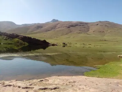 a body of water with a mountain in the background at Gite Oukaimeden in Oukkainrdem