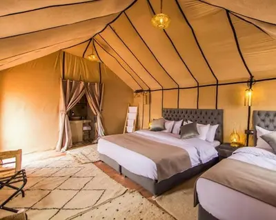 a bedroom with two beds in a tent at sahara oasis camp in Merzouga