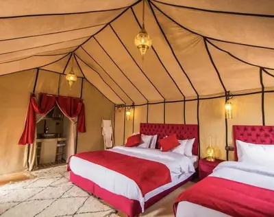 a bedroom with two beds in a tent at sahara oasis camp in Merzouga