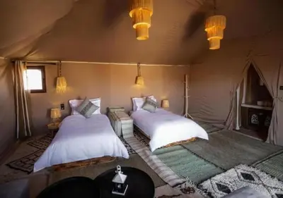 a bedroom with two beds in a tent at sahara oasis camp in Merzouga