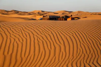a desert with a house in the middle of it at Camp Golden Desert Morocco in Mhamid