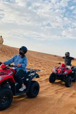 two people riding on atvs in the desert at Camp Golden Desert Morocco in Mhamid