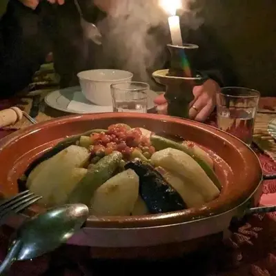 a plate of food on a table with a candle at Camp Golden Desert Morocco in Mhamid
