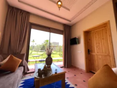 a living room with a couch and a table and a window at Dar Fatima Tamazouzt in Marrakech