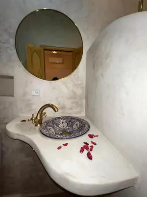 a bathroom sink with a mirror and a plate on it at Dar Fatima Tamazouzt in Marrakech