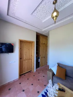 a living room with a couch and a tv at Dar Fatima Tamazouzt in Marrakech