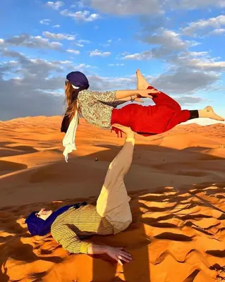 two people laying in the sand in the desert at Erg Chigaga Regency Camp in El Gouera