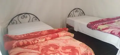 two twin beds in a room with at Erg Chigaga Regency Camp in El Gouera