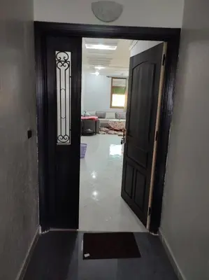 a hallway with a black door and a living room at Thé good stay4 midelt in Midelt