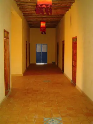 an empty hallway with a blue door in a building at Chez Meriem in Merzouga