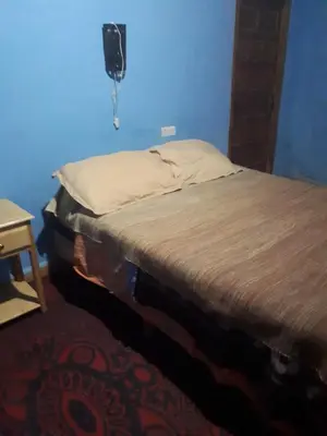 a bed in a room with a blue wall at Chez Meriem in Merzouga