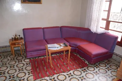 a living room with a purple couch and a table at Dar El Karam Fez in Fès