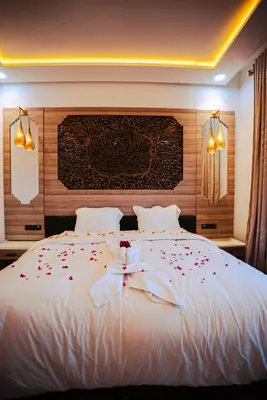 a bedroom with a white bed with flowers on it at Kasbah Merzouga in Merzouga