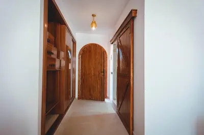 a hallway with wooden doors in a house at Kasbah Merzouga in Merzouga