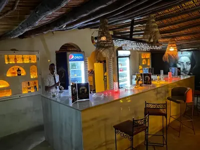 a man standing at a bar in a restaurant at Kasbah Merzouga in Merzouga