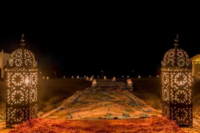 a pathway with lights in a field at night at Soleil Camp & Camel Trekking in Merzouga