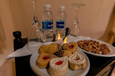 a table with two plates of pastries and bottles of water at Soleil Camp & Camel Trekking in Merzouga