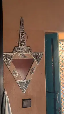 a star hanging on a wall next to a door at Kasbah Mashallah in Tagounite