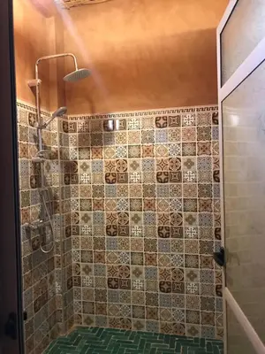a bathroom with a shower with a tiled wall at Kasbah Mashallah in Tagounite
