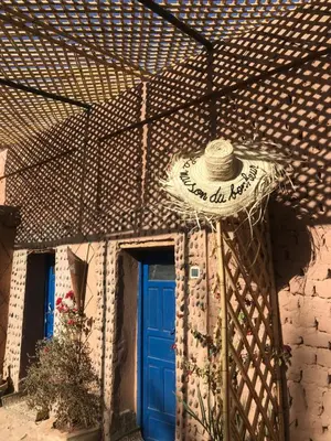 a building with a blue door and a sign on it at Kasbah Mashallah in Tagounite
