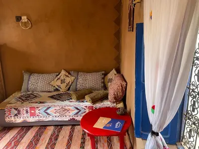 a small room with a couch and a red table at Kasbah Mashallah in Tagounite