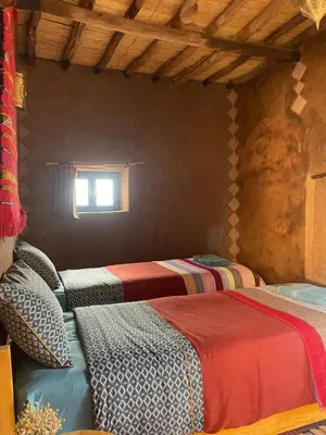 a room with two beds and a window at Kasbah Mashallah in Tagounite