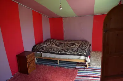a bedroom with a bed and red and white stripes at Camp Mbark authentic in Mhamid