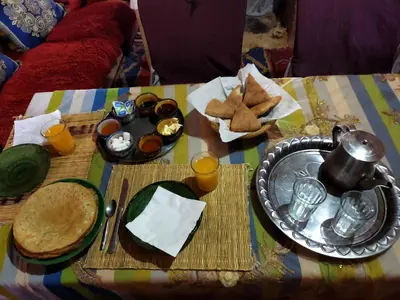 a table with a plate of food on a table at Camp Mbark authentic in Mhamid