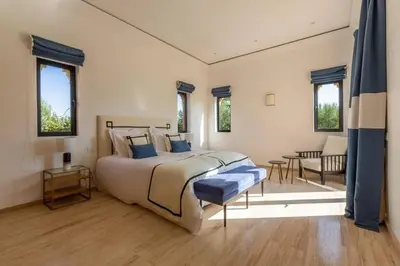 a bedroom with a large bed and a table at Somptueuse Villa louée avec le personnel de maison in Marrakech