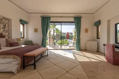 a large bedroom with a bed and a large window at Somptueuse Villa louée avec le personnel de maison in Marrakech