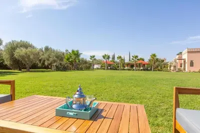 a lantern sitting on a wooden table in a field at Somptueuse Villa louée avec le personnel de maison in Marrakech