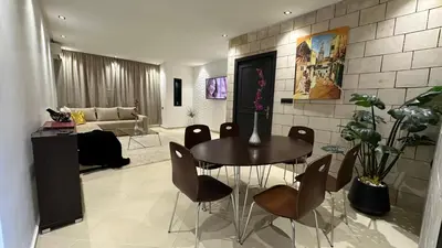 a living room with a table and chairs and a couch at Luxury appartement Fes in Fès