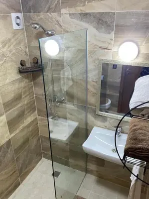 a bathroom with a glass shower and a sink at Appart luxueux sécurisé parking 10 min Medina in Fès