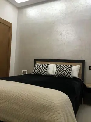 a bedroom with a bed with black and white pillows at Appart luxueux sécurisé parking 10 min Medina in Fès