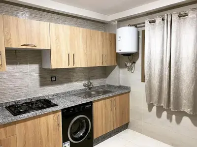 a kitchen with a sink and a washing machine at Appart luxueux sécurisé parking 10 min Medina in Fès