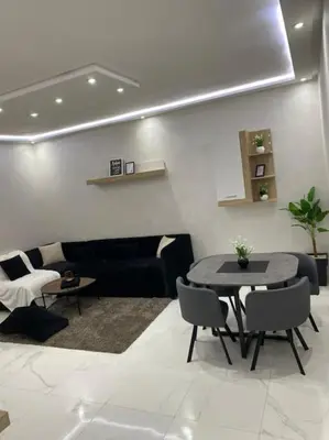 a living room with a table and a couch at Appart luxueux sécurisé parking 10 min Medina in Fès