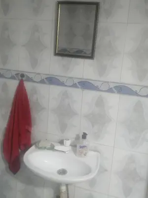 a bathroom with a white sink and a mirror at Magnifique appartement avec un bon emplacement in Fès