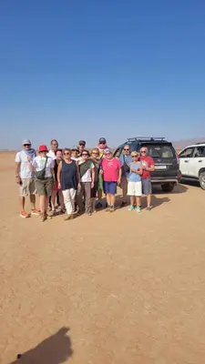 a group of people posing for a picture on the beach at Erg Chegaga Camp Excursions in Mhamid