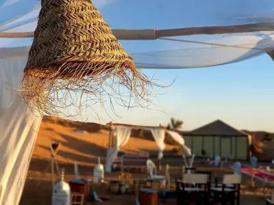 a close up of a white tent with tables and chairs at Nomadic Sands Retreat in Merzouga