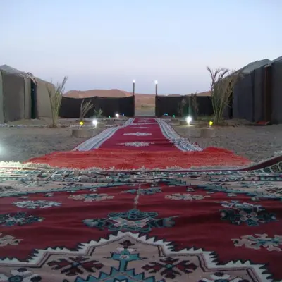 a red carpet in the middle of the desert at Bivouac la fibule des Dunes in Merzouga